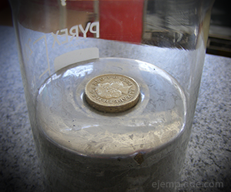 Moneda sobre superficie de Mercurio. Se sostiene en la superficie